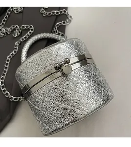 Macro shot of silver quilted bucket bag with kiss-lock closure and metal chain strap