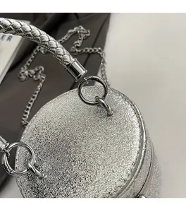 Detail of silver bucket bag showing textured metallic leather and woven metal handle