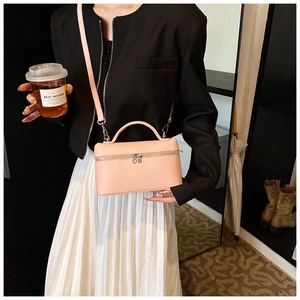 Detalle de bolso bandolera de cuero rosa con textura de grano y correa ajustable