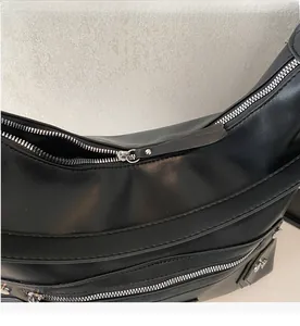 Detailed close-up of smooth silver-tone zippers and premium black leather texture on tote bag