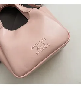Close-up of light pink PU leather bucket bag with embossed MUHETI SHI SHANG lettering