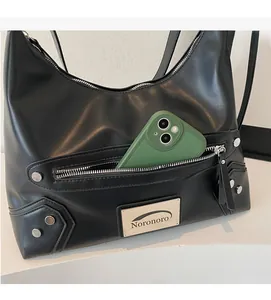Detailed view of black faux leather crossbody bag showing storage space for a mobile phone