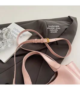 Detail of adjustable strap and gold buckle on a premium pink leather bucket bag