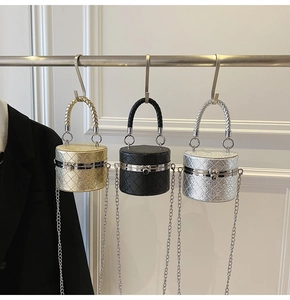 Close-up of quilted cylinder bucket bags with woven handles in gold, black and silver