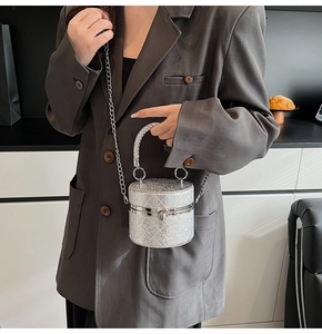 Details der silbernen Glitzer-Zylindertasche mit Kettengurt und Steppmuster