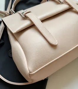 Dettaglio della pelle sintetica opaca e cuciture precise sulla borsa beige