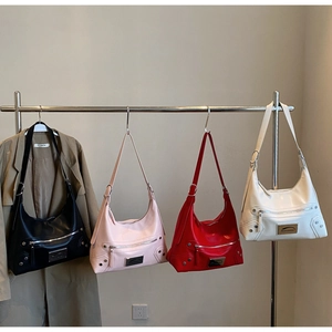 Close-up of motorcycle style shoulder bags with metallic rivets and long zipper tassels