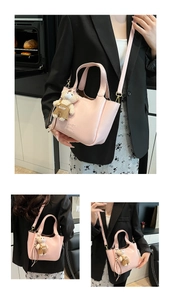Detail view of pink glossy bucket bag with golden hardware and cute bear charm