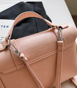 Dettagli di una borsa in pelle rosa con fibbie metalliche e cuciture rifinite