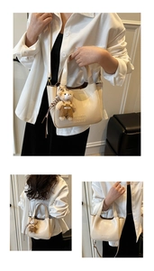Detail of cream bucket bag with cute bear charm and adjustable shoulder strap