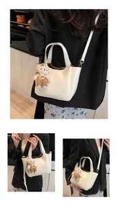 Three views of cream oil wax bucket bag with teddy bear charm and adjustable straps