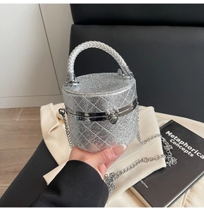 Detail der silbernen Pailletten-Eimertasche mit Steppmuster und gewebtem Metallgriff