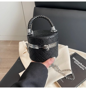 Detail of black quilted mini vanity bag with shimmering sequins and silver chain strap