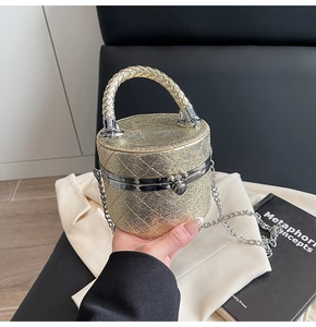 Detail einer goldenen gesteppten Mini-Beuteltasche mit Metallic-Finish und Kette