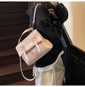 Close-up of the vintage pink satchel bag featuring decorative buckles and adjustable strap