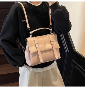 Elegante borsa a mano rosa con fibbie indossata da una modella in uno stile casual
