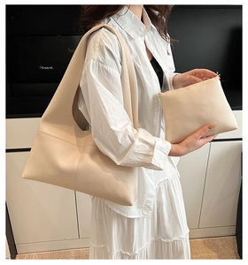 Detail of minimalist cream beige tote bag set with pebble leather texture on a model