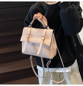 Detail of light pink faux leather satchel with silver buckles and convertible straps