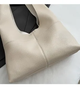Close-up of beige tote bag featuring high-quality pebble grain texture and handmade stitching