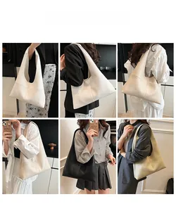 Modern minimalist large tote bag with litchi grain texture shown on shoulder model