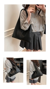 Detail of black pebbled leather tote bag with soft texture and spacious interior