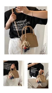 Detail shot of Korean style simple litchi pattern shell handbag with cute teddy bear plush pendant.