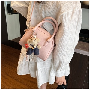 Chic pink dome crossbody bag for women, cute bear pendant, stylish textured PU leather handbag.