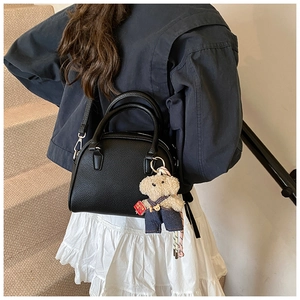 Detailed view of the chic Korean style pebble leather handbag with cute bear charm for daily wear.