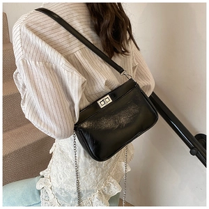 Piccola borsa quadrata nera lucida con chiusura a rotazione argento sul modello