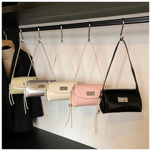 Cinq sacs à bandoulière en cuir verni brillant de différentes couleurs sur un rack