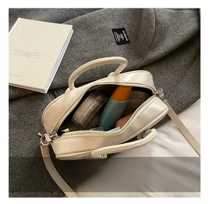 Vue intérieure du sac bowling beige montrant la capacité pour cosmétiques et essentiels
