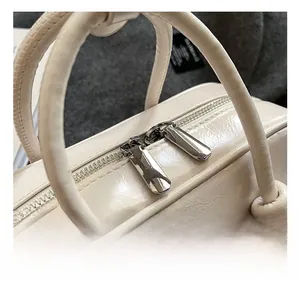 Détails des doubles fermetures éclair en métal et cuir crème de sac à main