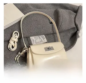 Détail du sac en cuir blanc cassé avec fermoir argenté et bandoulières élégantes