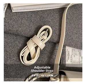 Détail de la bandoulière réglable en similicuir blanc cassé avec boucle en métal argenté