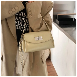 Détail d'un sac à main beige brillant en PU avec fermoir rotatif argenté