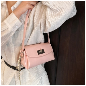 Vue détaillée du sac à main en cuir verni rose avec fermoir argenté et breloque