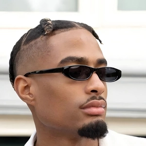 Retro small oval frame sunglasses in black finish worn by a male model in daylight