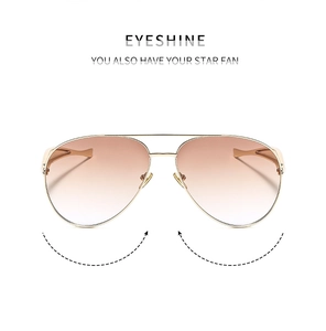 Close-up of golden metal aviator sunglasses featuring gradient lenses and double bridge