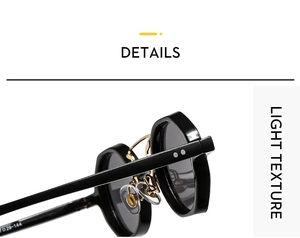 Close-up of retro black frame sunglasses with golden metal bridge and silver rivets detail