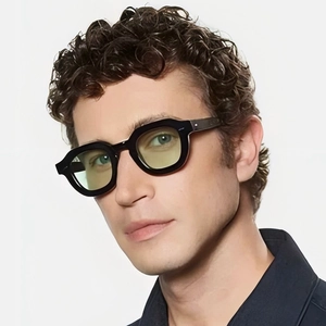 Männliches Model trägt modische Polygon-Sonnenbrille mit schwarzem Rahmen und gelben Gläsern