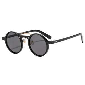 Retro round black frame sunglasses with golden metal bridge on white background