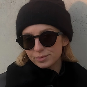 Minimalist black round frame sunglasses with matching knit beanie on model for daily sun protection