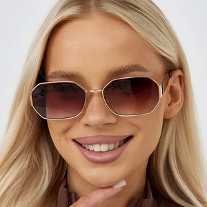 Polygonal metal sunglasses with gold frames and brown gradient lenses on model