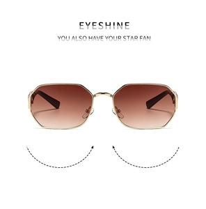 Detailed view of hexagonal gold metal frames and brown gradient lenses on sunglasses