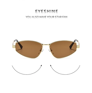 Detailed close-up of retro cat eye sunglasses with gold metal frame and dark brown lenses