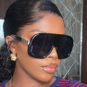 Fashionable black shield sunglasses with oversized frames and elegant gold metal accents