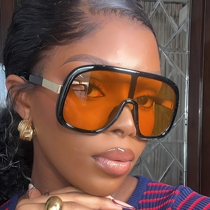 Fashionable oversized black frame sunglasses with amber lenses and gold accents for women
