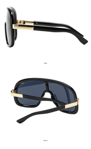 Detail view of oversized black sunglasses with gold metal side and back temple design