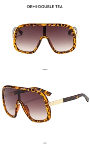 Detail view of large tortoise shell sunglasses with gradient tea lenses and gold metal accents