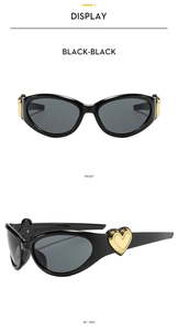 Detail of cat-eye sunglasses featuring golden heart-shaped metal accents on the black temples